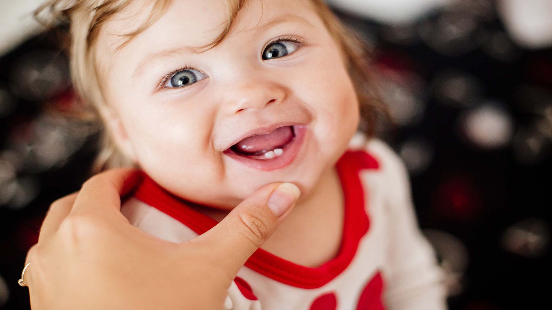 smiling baby with lower central incisors showing