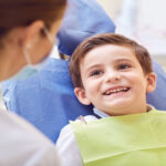Young boy excitedly looking at dentist during an appointment.