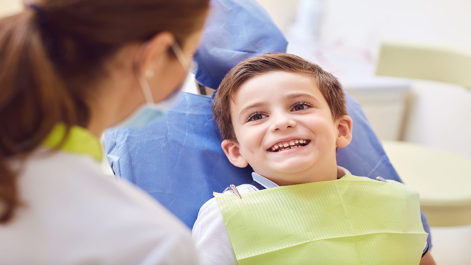 Young boy excitedly looking at dentist during an appointment.