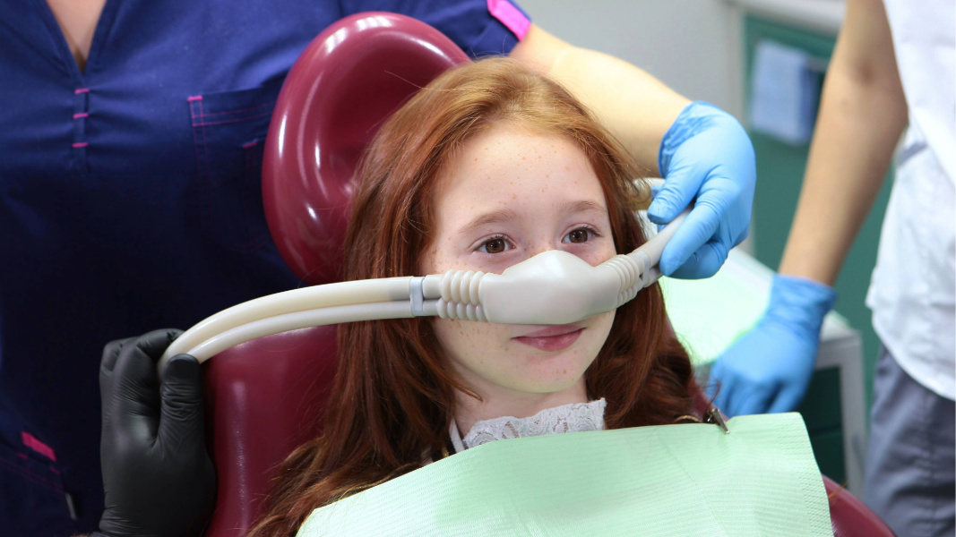 Girl in dentist’s chair receiving sedation dentistry.