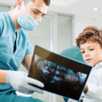 Boy looking at dental x-ray with dentist.