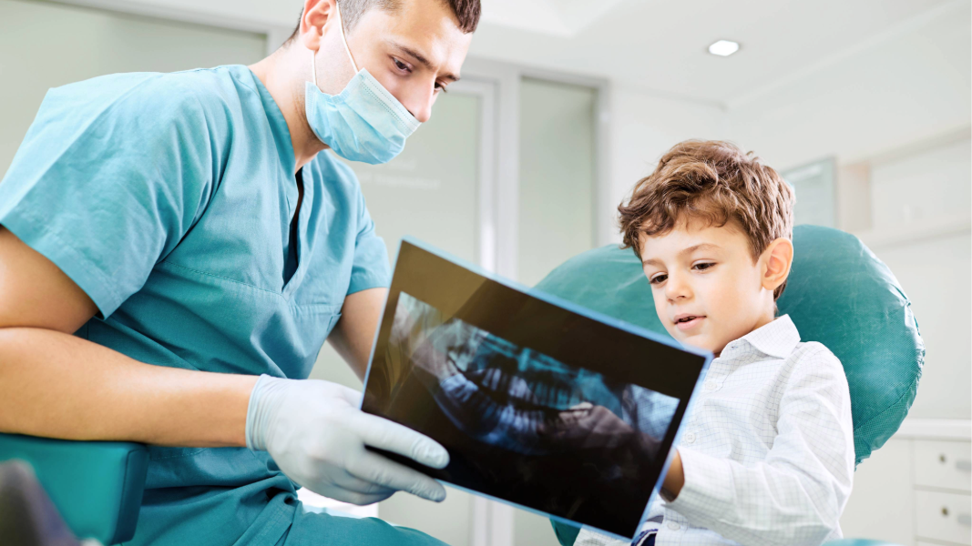 Boy looking at dental x-ray with dentist.