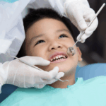 Boy in dentist’s chair receiving dental exam.