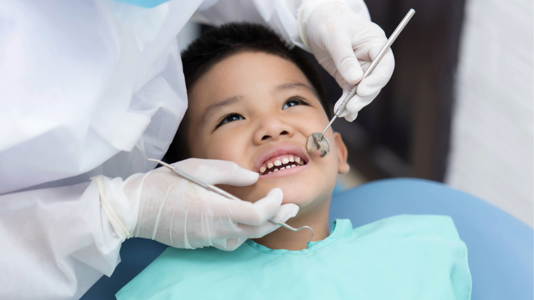 Boy in dentist’s chair receiving dental exam.